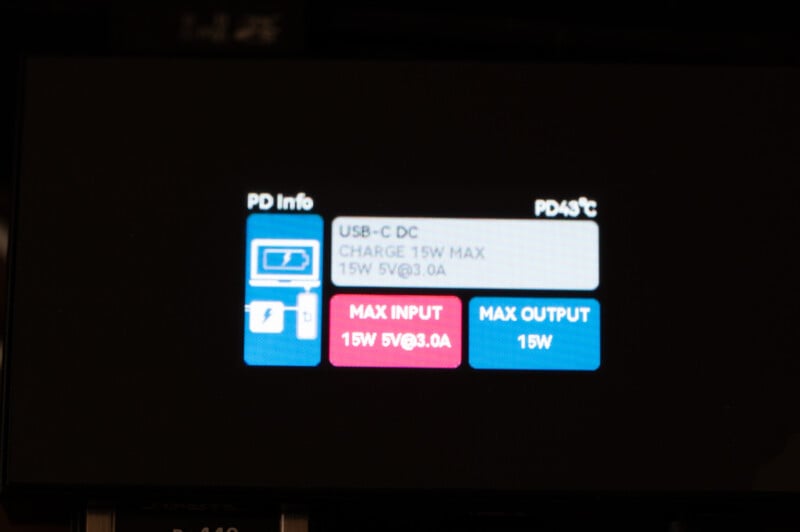 A close-up of a digital display on a device. The screen shows charging information with labels: "USB-C DC," "CHARGE 15W MAX," and "15W 5V@3.0A." It also indicates the maximum input as "15W 5V@3.0A" and maximum output as "15W.