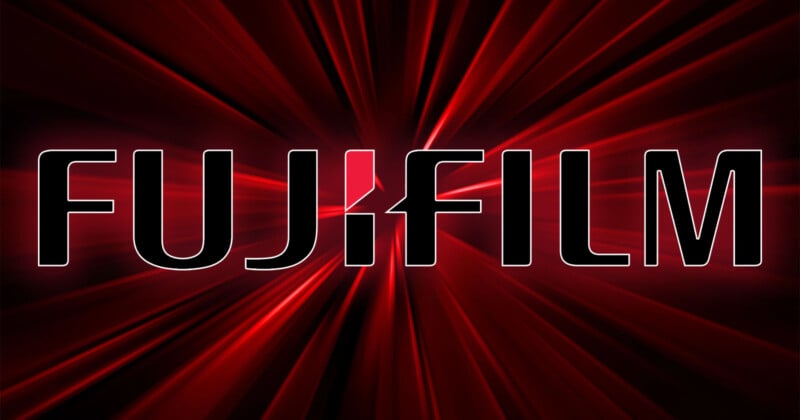 A glowing red background with the bold, uppercase text "FUJIFILM" displayed prominently in black with white outlines. A stylized design in white and red is used for the "J" in "FUJIFILM". Radiating lines give a dynamic effect to the background.