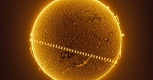 A highly detailed image of the Sun's surface, showcasing its texture and solar activities. A series of rectangles, possibly representing an object or transit, crosses diagonally from the bottom left to the top right, creating a repetitive pattern on the Sun.