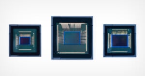 Three microchips are displayed side by side against a plain, white background. Each has a similar square-shaped central processing unit with intricate wiring visible around the perimeter. The chips vary in size, with the middle one being the largest.